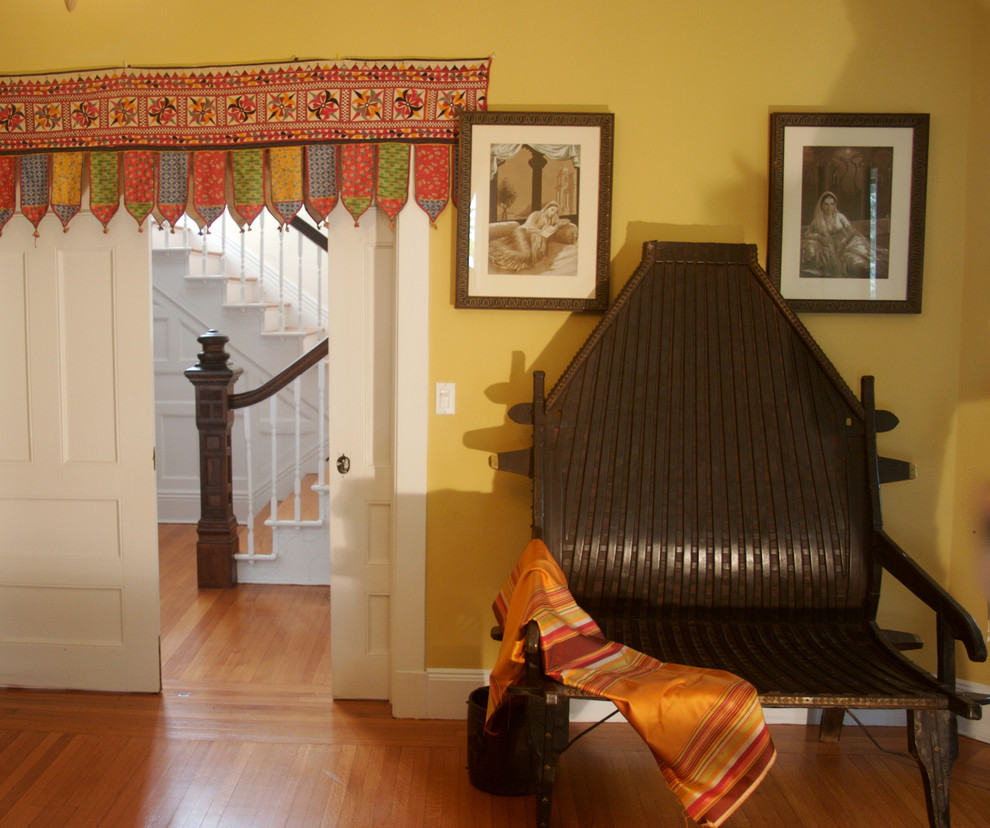 Esempio di un soggiorno etnico con pareti gialle e pavimento in legno massello medio