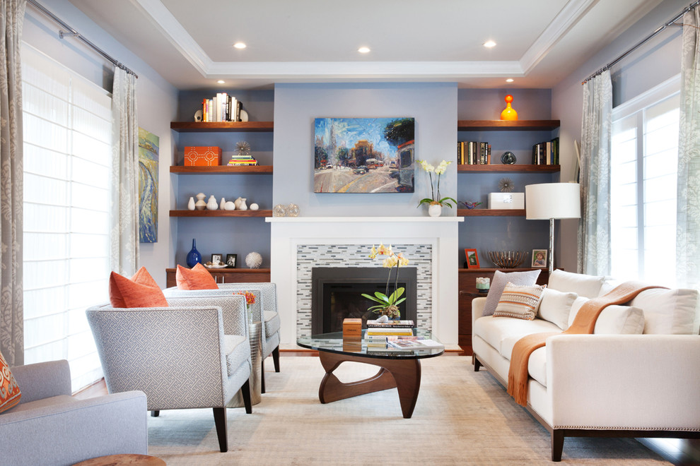 Пример оригинального дизайна: гостиная комната в стиле неоклассика (современная классика) с с книжными шкафами и полками, синими стенами и стандартным камином