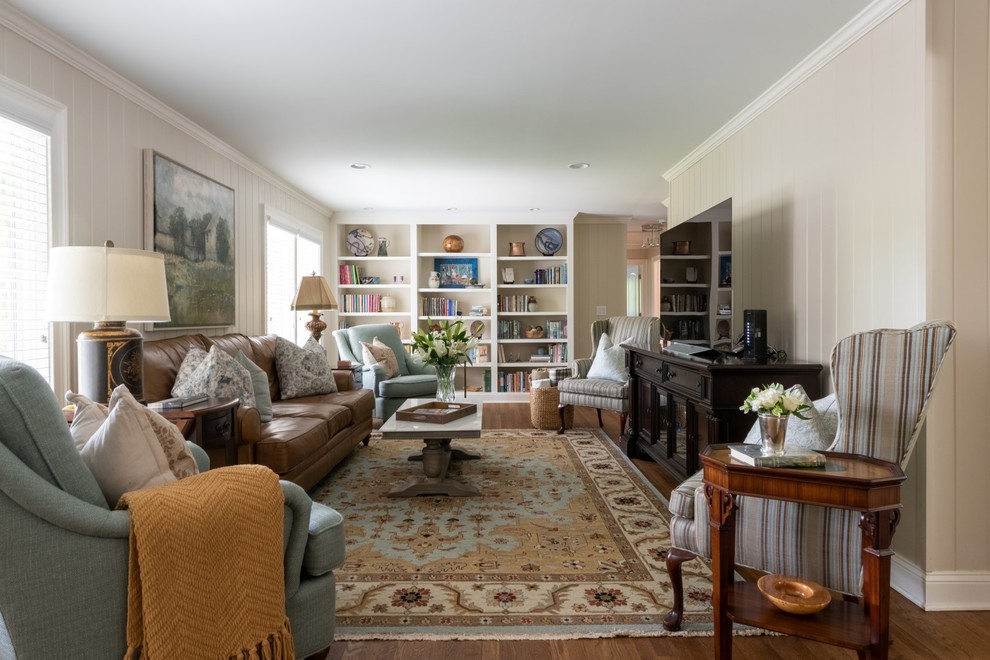 Стильный дизайн: гостиная комната в классическом стиле с бежевыми стенами, паркетным полом среднего тона, отдельно стоящим телевизором, коричневым полом и коричневым диваном - последний тренд