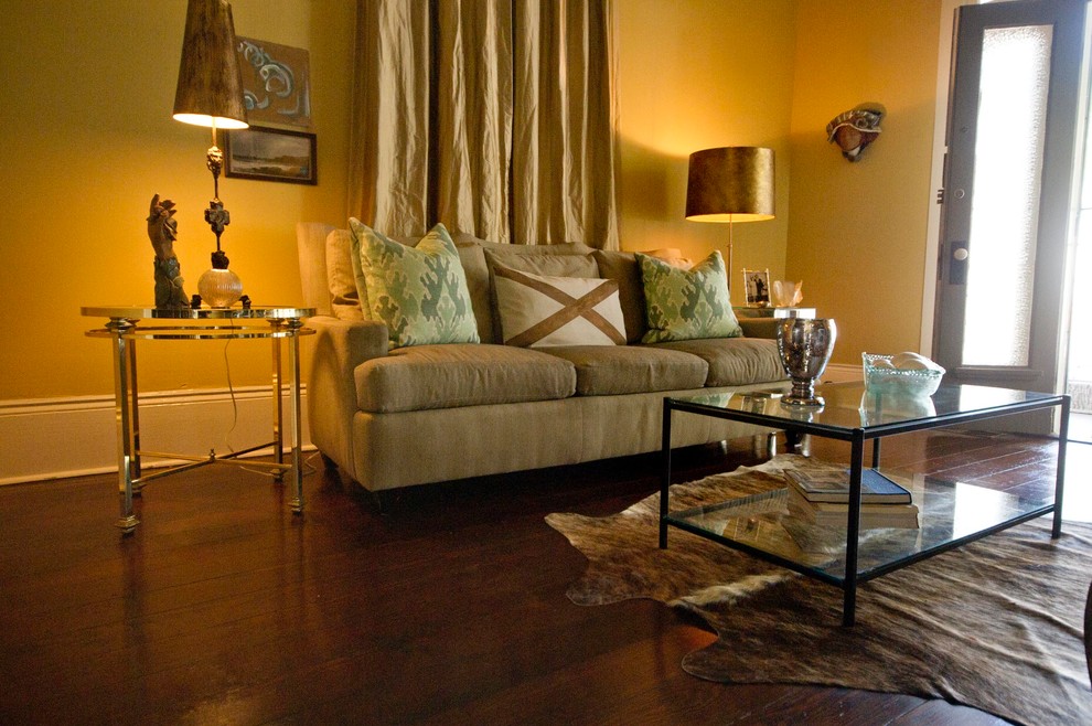 Источник вдохновения для домашнего уюта: изолированная гостиная комната среднего размера в стиле неоклассика (современная классика) с желтыми стенами, темным паркетным полом, стандартным камином, фасадом камина из штукатурки и телевизором на стене