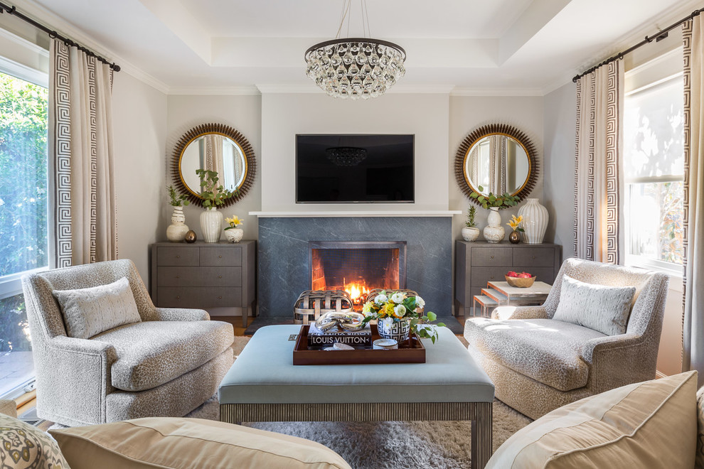 На фото: гостиная комната в стиле неоклассика (современная классика) с серыми стенами, паркетным полом среднего тона, стандартным камином, телевизором на стене и коричневым полом с