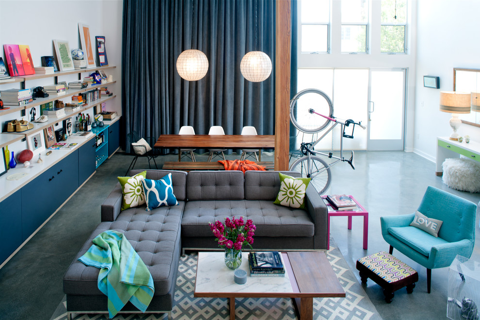 Источник вдохновения для домашнего уюта: гостиная комната в стиле фьюжн с с книжными шкафами и полками, бетонным полом и синими шторами