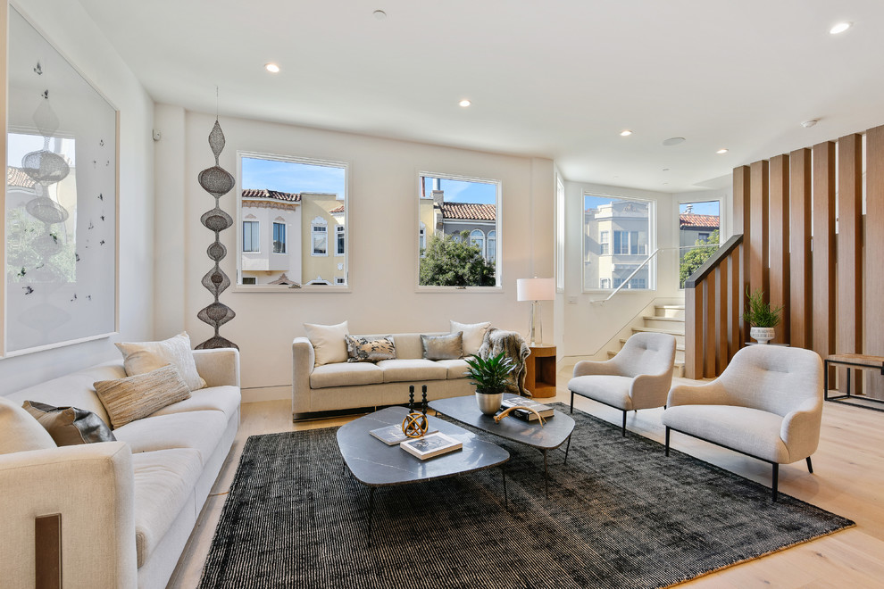 Photo of a contemporary formal and grey and cream living room in San Francisco with white walls, light hardwood flooring, no tv and beige floors.