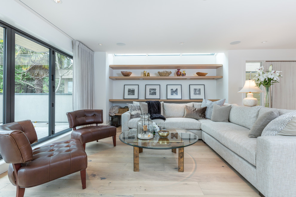Contemporary living room in Vancouver with white walls and light hardwood flooring.