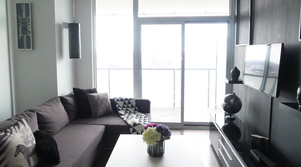 Foto di un piccolo soggiorno contemporaneo aperto con sala formale, pareti nere, parquet scuro, nessun camino e TV a parete