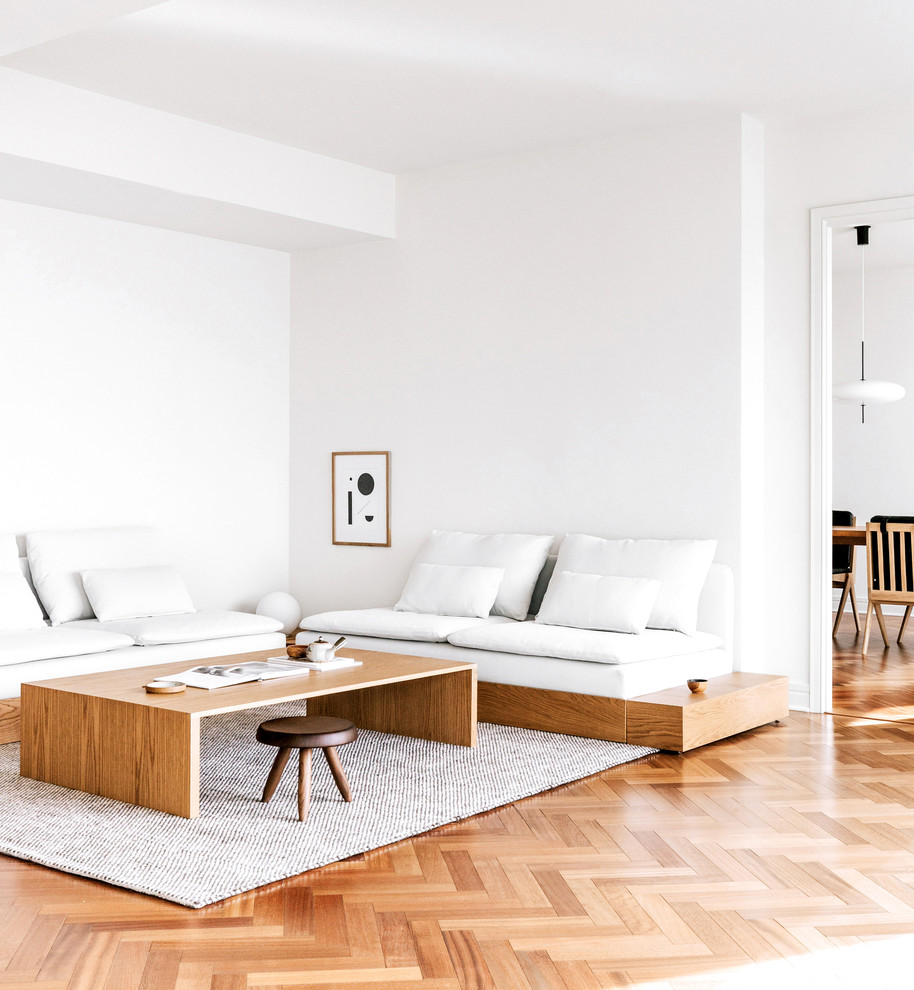 Immagine di un soggiorno contemporaneo di medie dimensioni e chiuso con pareti bianche, pavimento in legno massello medio, pavimento beige, nessun camino e nessuna TV