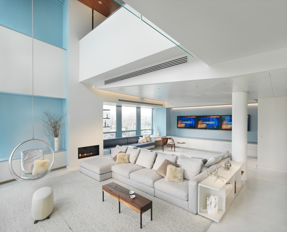 На фото: огромная открытая, парадная гостиная комната в современном стиле с синими стенами и горизонтальным камином без телевизора с