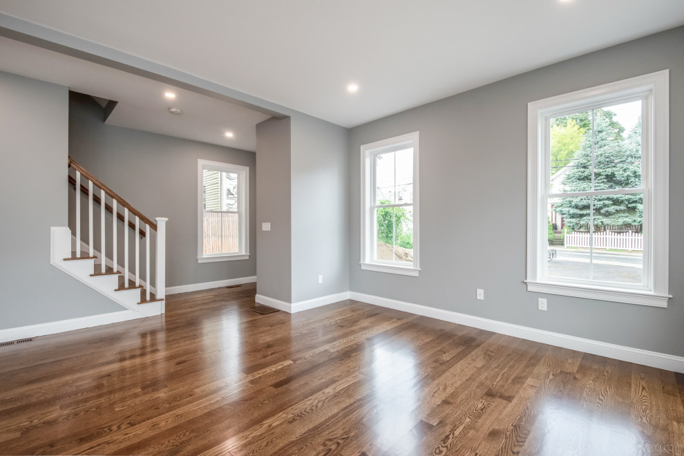 Landhausstil Wohnzimmer mit blauer Wandfarbe, braunem Holzboden, braunem Boden und gewölbter Decke in Boston