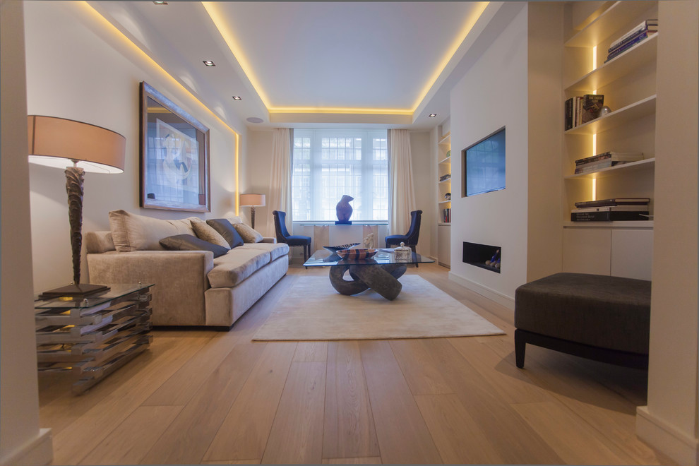 Ejemplo de salón abierto actual de tamaño medio con paredes beige, suelo de madera clara y marco de chimenea de yeso