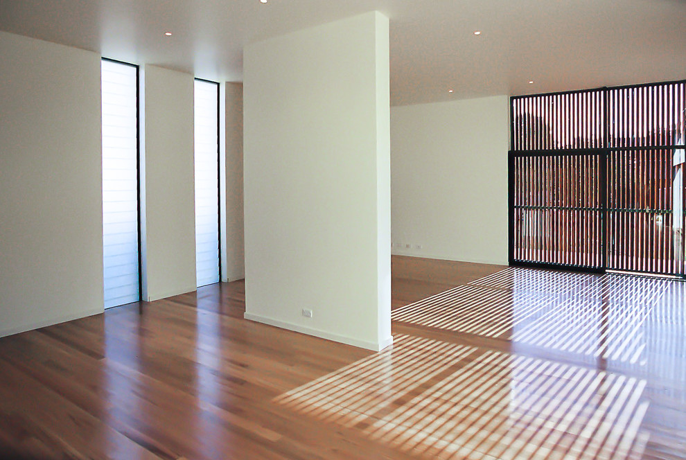 На фото: большая гостиная комната в современном стиле с белыми стенами, паркетным полом среднего тона и коричневым полом с
