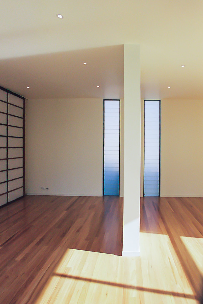 Immagine di un grande soggiorno design con pareti bianche, pavimento in legno massello medio e pavimento marrone