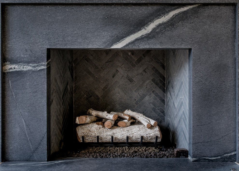 ダラスにある中くらいなコンテンポラリースタイルのおしゃれなリビング (白い壁、淡色無垢フローリング、標準型暖炉、石材の暖炉まわり、テレビなし) の写真