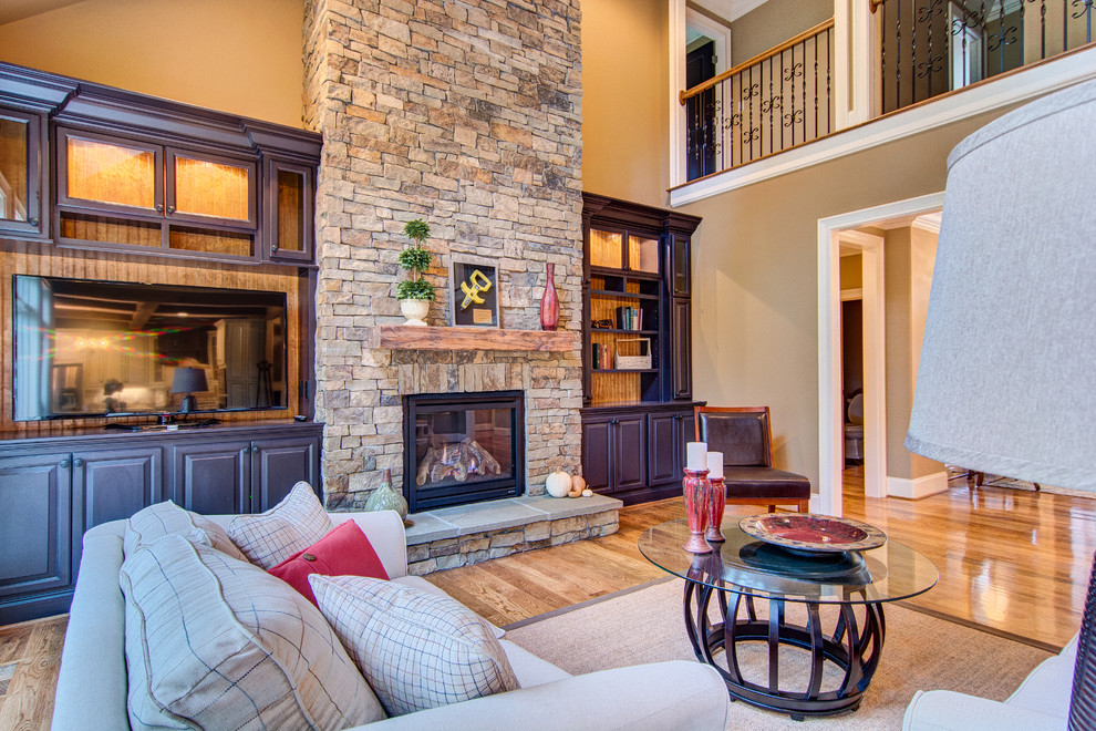 Inspiration for a large timeless open concept brown floor living room remodel in Raleigh with beige walls, a standard fireplace, a stone fireplace and a tv stand
