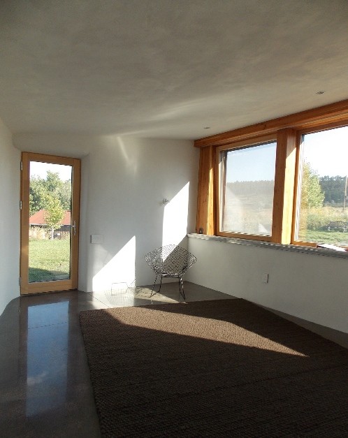 На фото: большая изолированная гостиная комната в современном стиле с белыми стенами и бетонным полом с