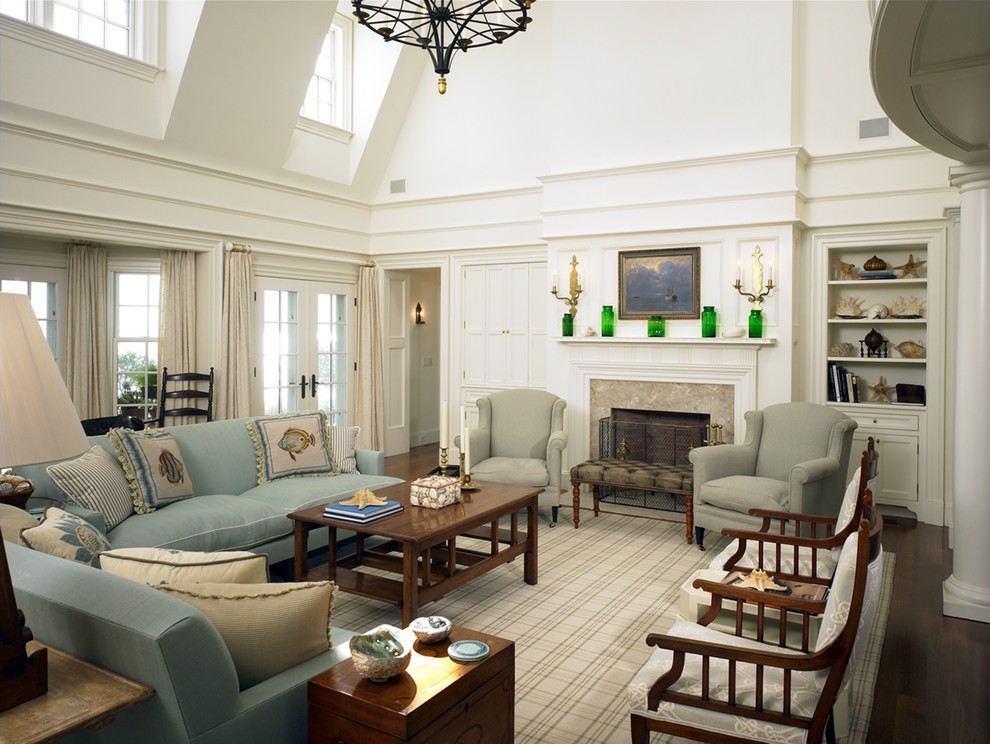 Стильный дизайн: гостиная комната в классическом стиле с белыми стенами, темным паркетным полом и стандартным камином - последний тренд