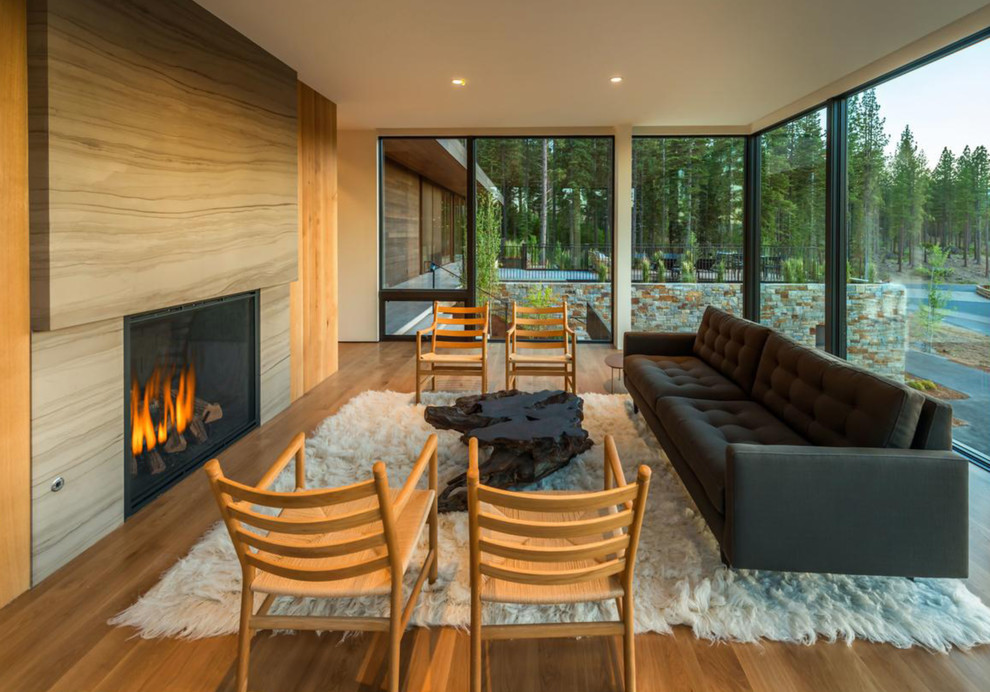 Foto de salón para visitas moderno con suelo de madera en tonos medios y todas las chimeneas
