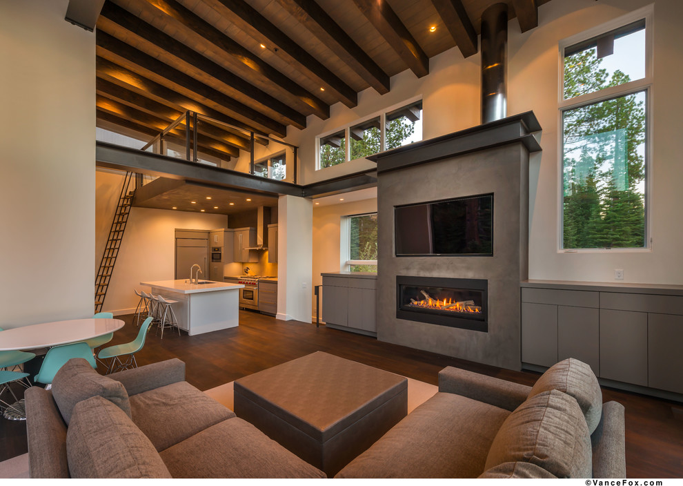 Foto de salón tipo loft minimalista grande con paredes blancas, suelo de madera oscura, todas las chimeneas, marco de chimenea de hormigón y pared multimedia