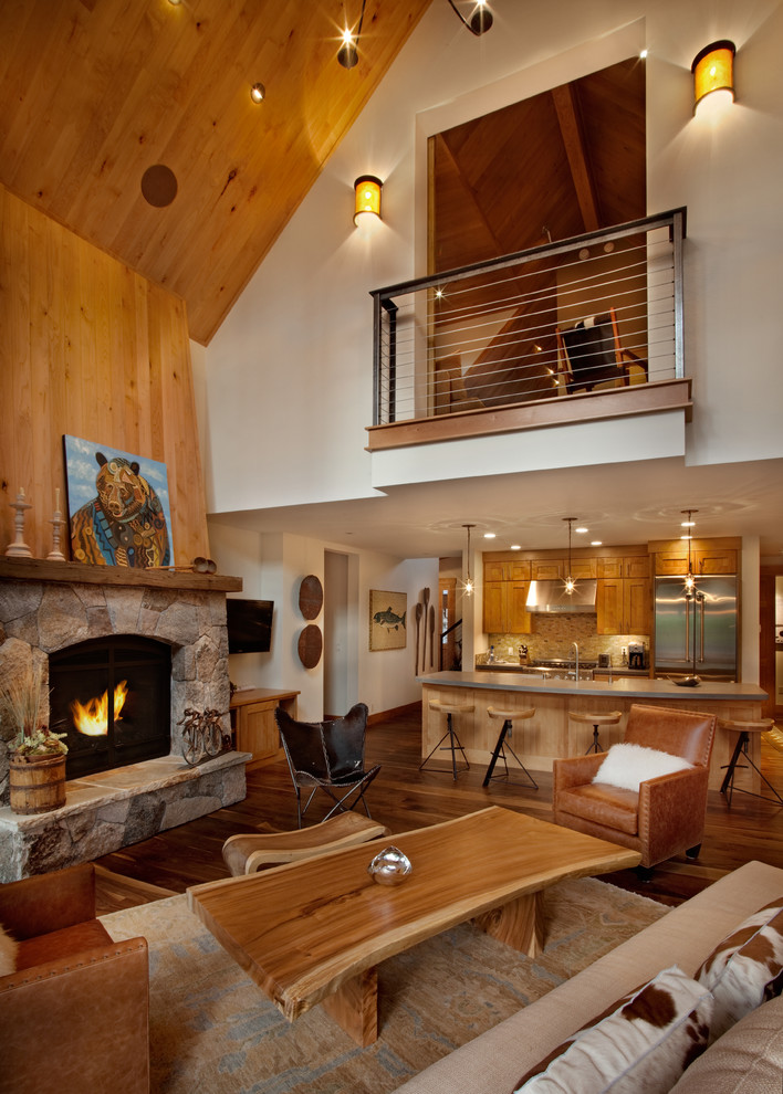 Cette photo montre un salon tendance ouvert et de taille moyenne avec une cheminée standard, un manteau de cheminée en pierre, un mur beige et un sol en bois brun.