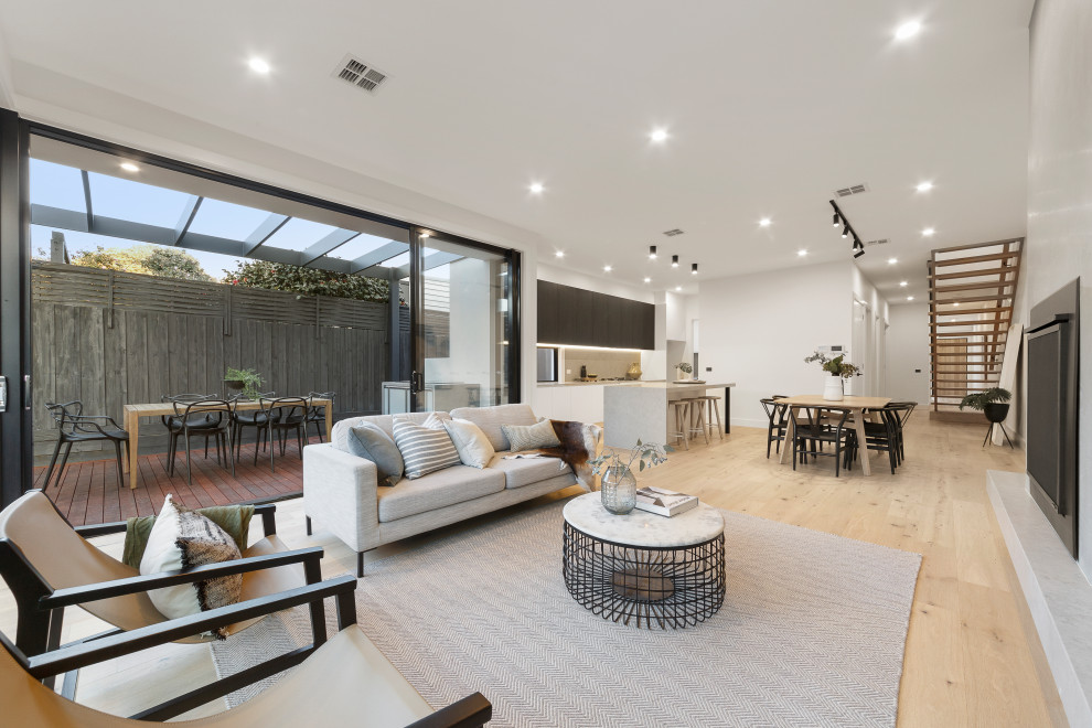 Living room - contemporary open concept light wood floor and beige floor living room idea in Melbourne with white walls