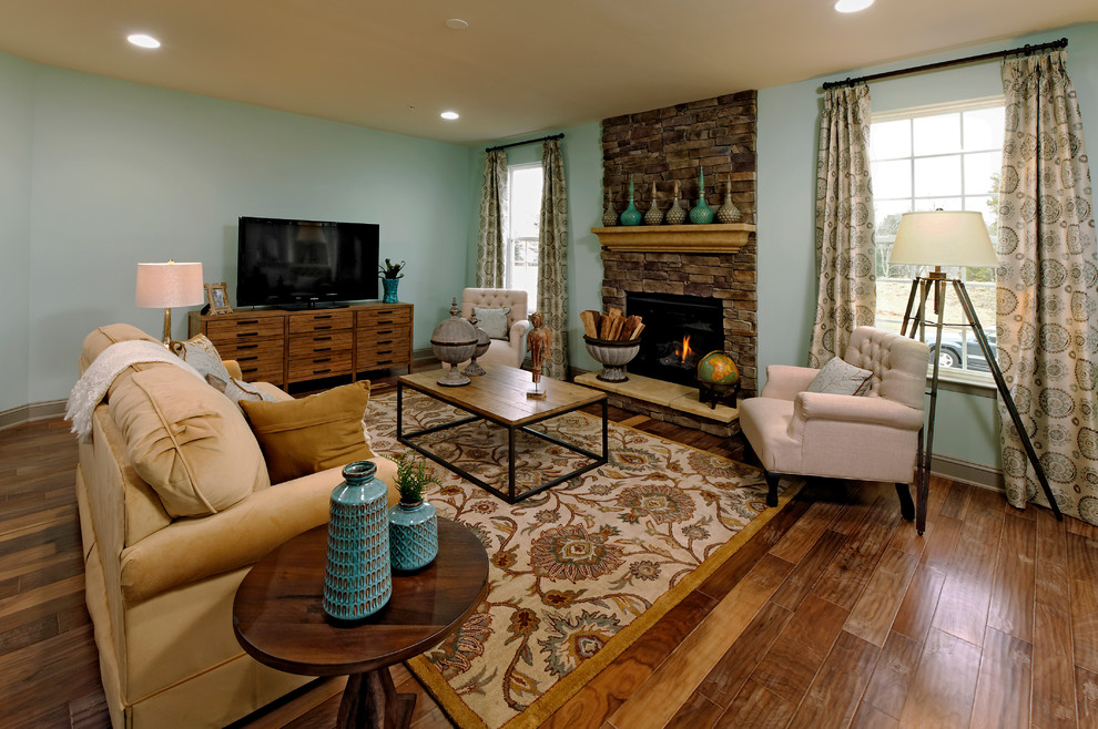Klassisches Wohnzimmer mit blauer Wandfarbe, Kamin, Kaminumrandung aus Stein und freistehendem TV in Atlanta