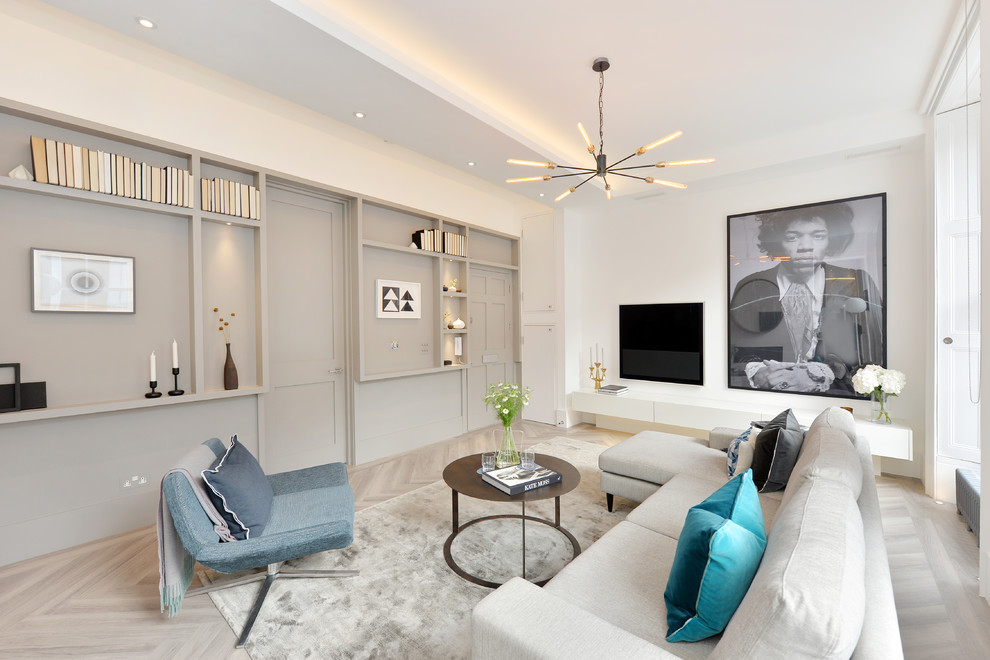 Immagine di un soggiorno minimal di medie dimensioni e aperto con pareti bianche, parquet chiaro e TV a parete