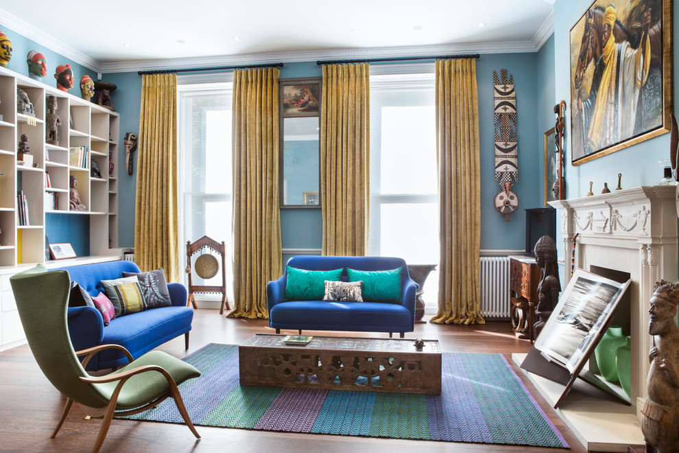 Inspiration pour un salon bohème avec un mur bleu, parquet foncé et une cheminée standard.
