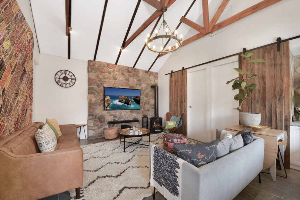 シドニーにある高級な中くらいなコンテンポラリースタイルのおしゃれなLDK (白い壁、セラミックタイルの床、薪ストーブ、石材の暖炉まわり、壁掛け型テレビ、グレーの床) の写真