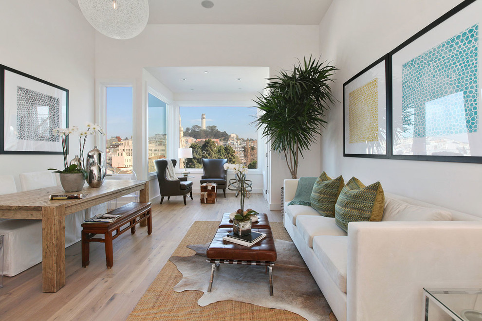 Immagine di un soggiorno design di medie dimensioni e aperto con pareti bianche e parquet chiaro