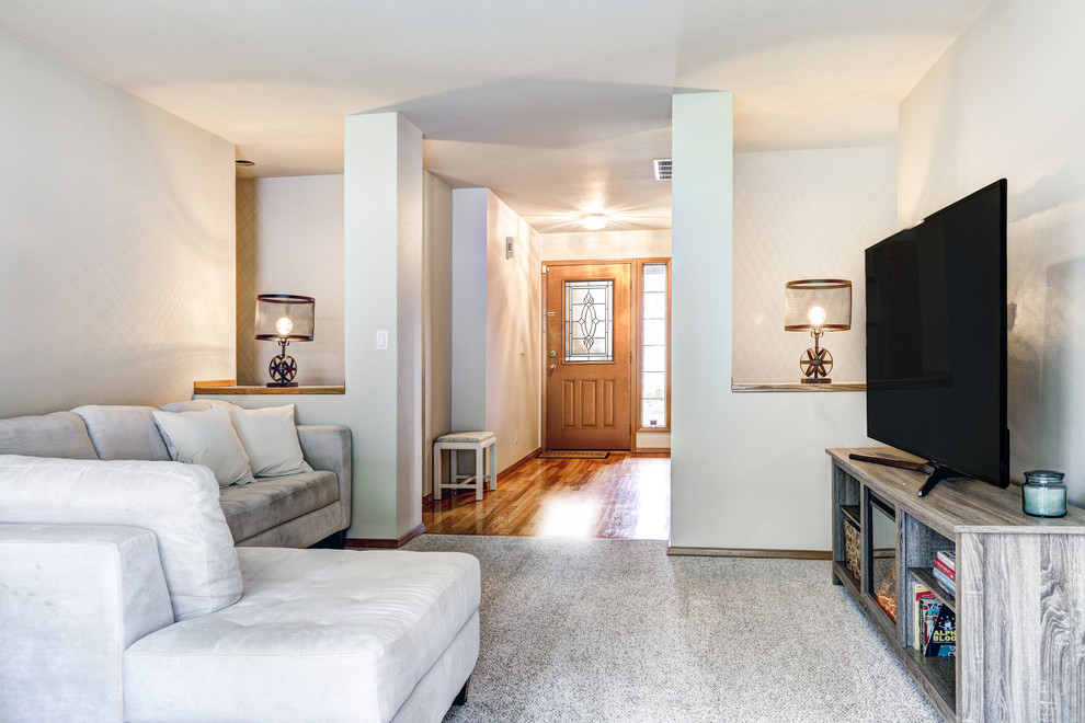 Aménagement d'un grand salon contemporain avec un mur gris, un sol en bois brun et un téléviseur indépendant.