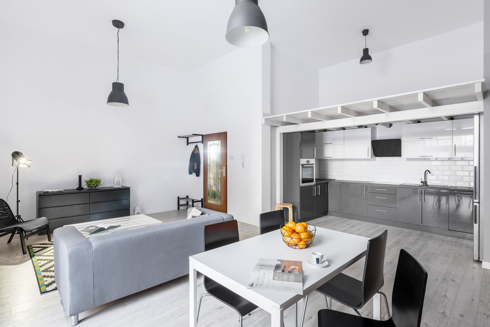 Foto di un grande soggiorno moderno aperto con pavimento grigio, pareti grigie e parquet chiaro