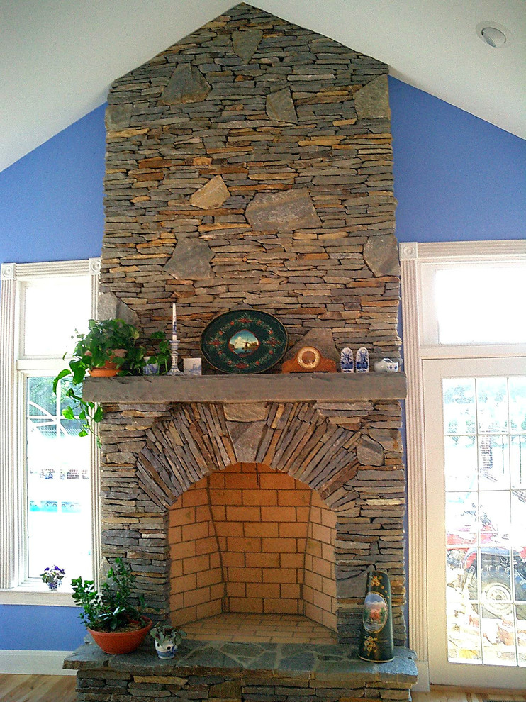 Photo of a traditional living room in Charlotte with blue walls and a stone fireplace surround.
