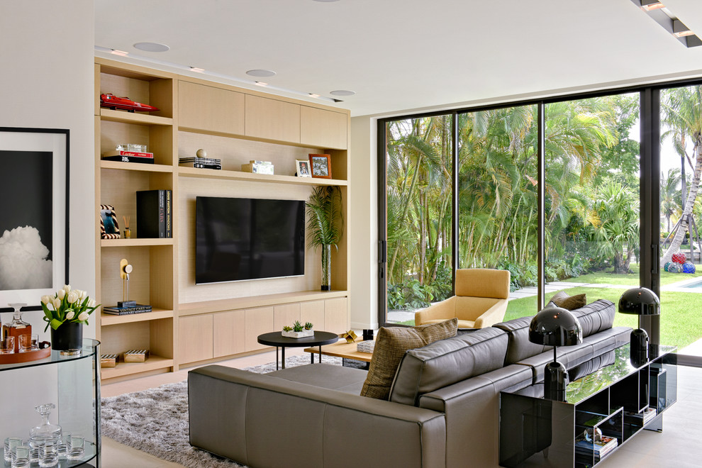 Cette photo montre un salon tendance avec un mur blanc, un téléviseur fixé au mur et un sol beige.
