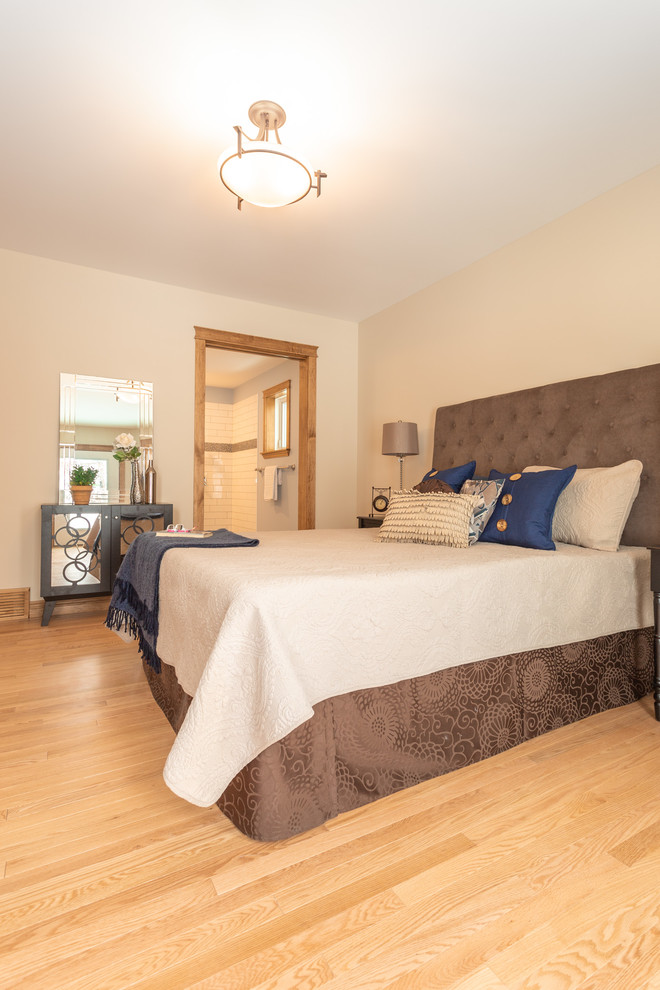 Imagen de dormitorio tradicional grande sin chimenea con paredes blancas, suelo de madera en tonos medios y suelo marrón
