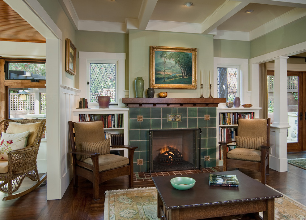 Cette image montre un grand salon craftsman ouvert avec un mur vert, parquet foncé, une cheminée standard, un manteau de cheminée en carrelage, une salle de réception, aucun téléviseur et un sol marron.