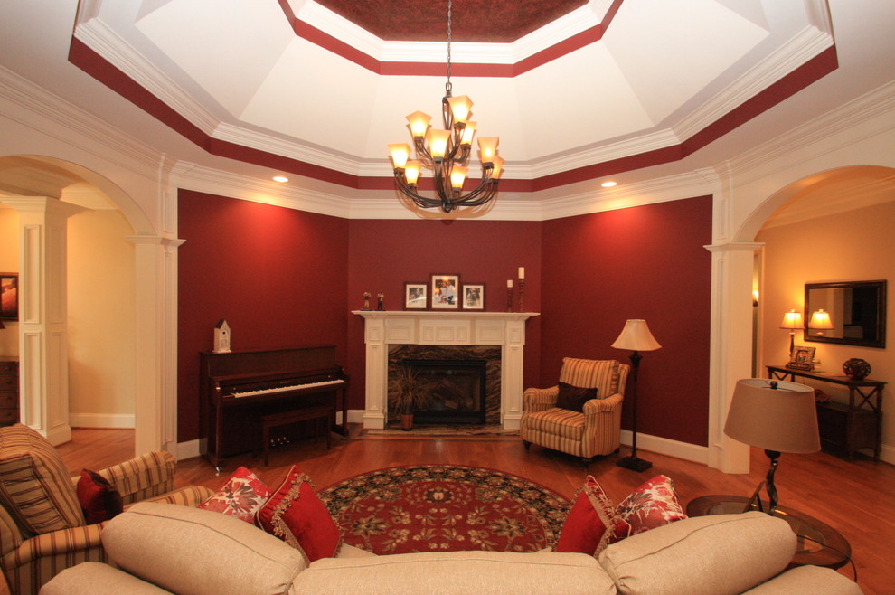 Idéer för att renovera ett mellanstort vintage separat vardagsrum, med ett finrum, röda väggar, mellanmörkt trägolv, en standard öppen spis, en spiselkrans i trä och brunt golv