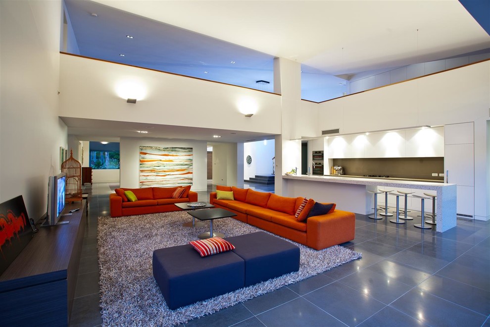Ejemplo de salón abierto contemporáneo grande con paredes blancas, suelo de baldosas de cerámica, televisor independiente y suelo gris