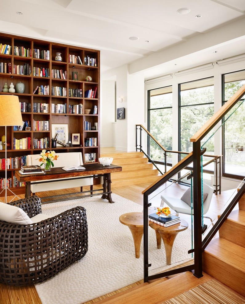 На фото: гостиная комната в стиле модернизм с с книжными шкафами и полками