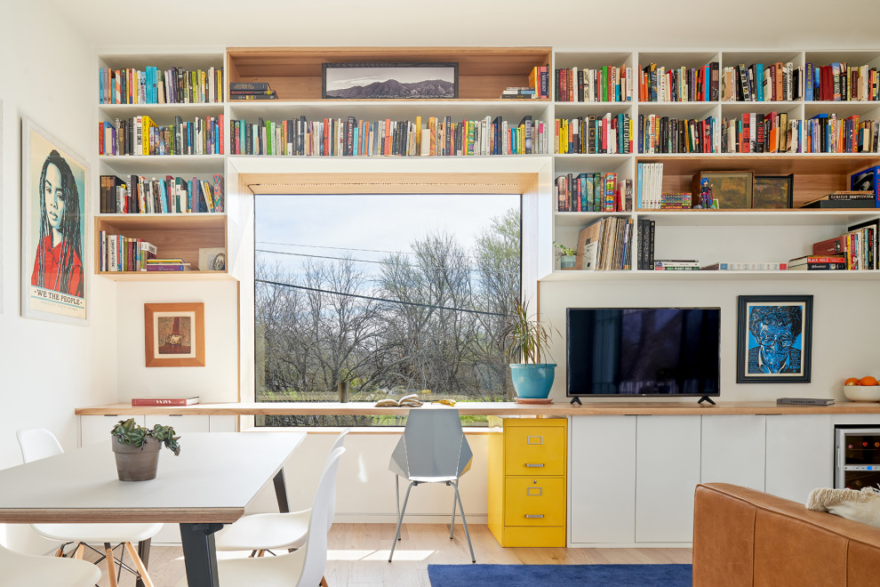 Bild på ett litet 50 tals vardagsrum, med vita väggar, mellanmörkt trägolv, en fristående TV och brunt golv
