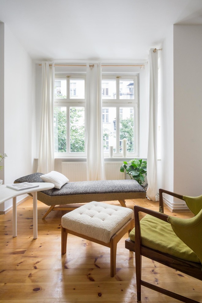Kleines, Fernseherloses, Abgetrenntes Mid-Century Wohnzimmer ohne Kamin mit weißer Wandfarbe, braunem Holzboden und braunem Boden in Berlin