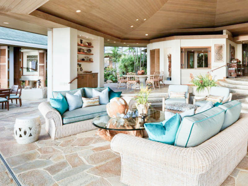 This is an example of an expansive world-inspired open plan living room in Hawaii with white walls, no fireplace, a built-in media unit, multi-coloured floors and a wood ceiling.