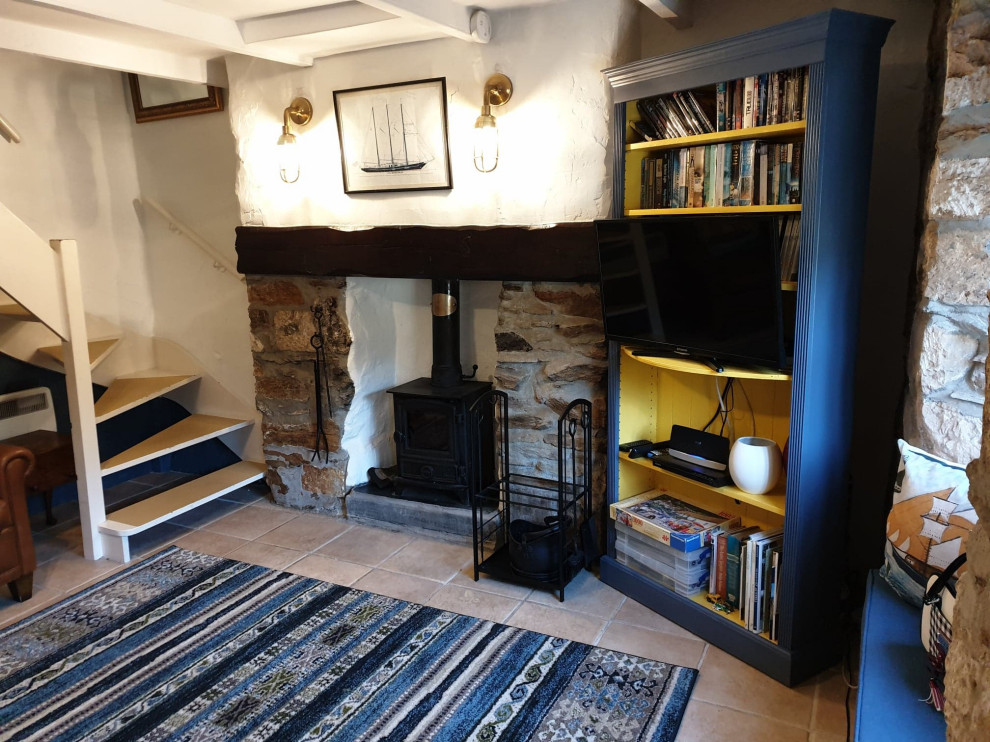 Exemple d'un petit salon bord de mer fermé avec un mur bleu, un sol en carrelage de céramique, un poêle à bois, un manteau de cheminée en brique et un sol beige.