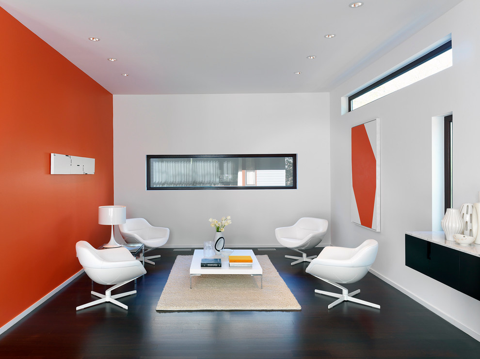 Immagine di un soggiorno design chiuso con pareti arancioni, nessun camino e nessuna TV