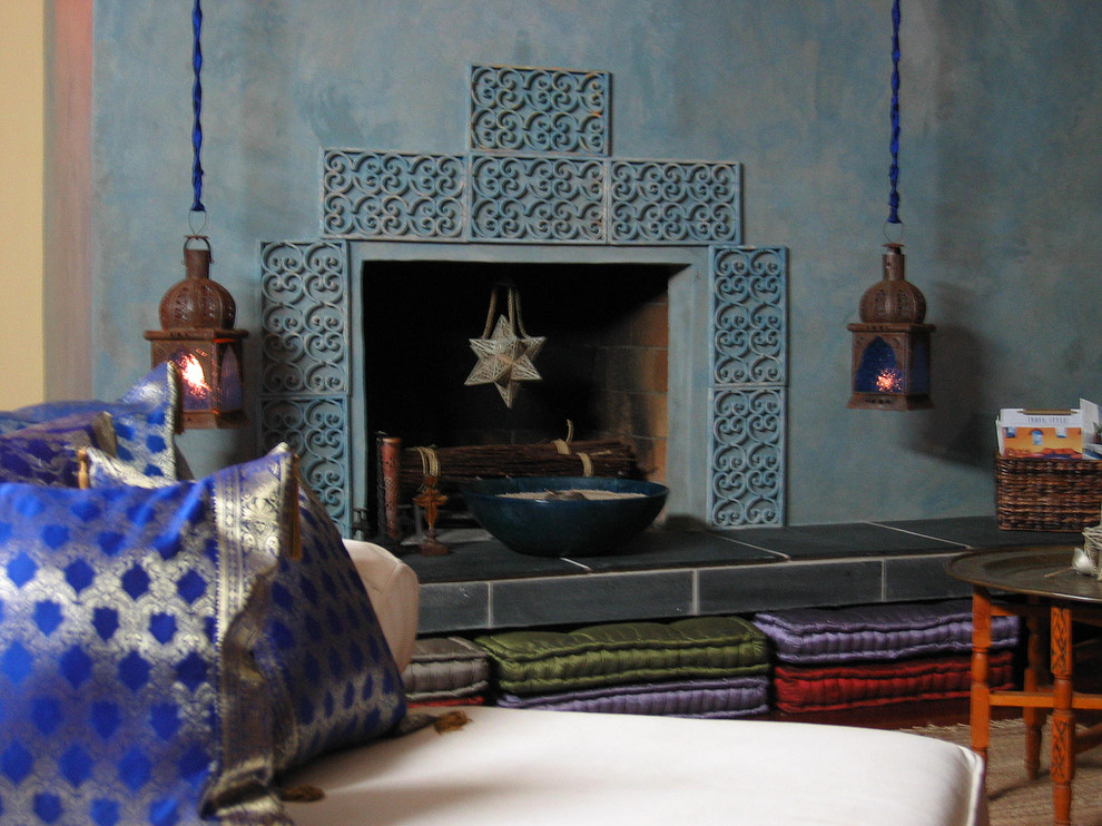 Mittelgroßes, Fernseherloses, Offenes Shabby-Style Wohnzimmer mit blauer Wandfarbe, braunem Holzboden, Kamin und Kaminumrandung aus Beton in Los Angeles