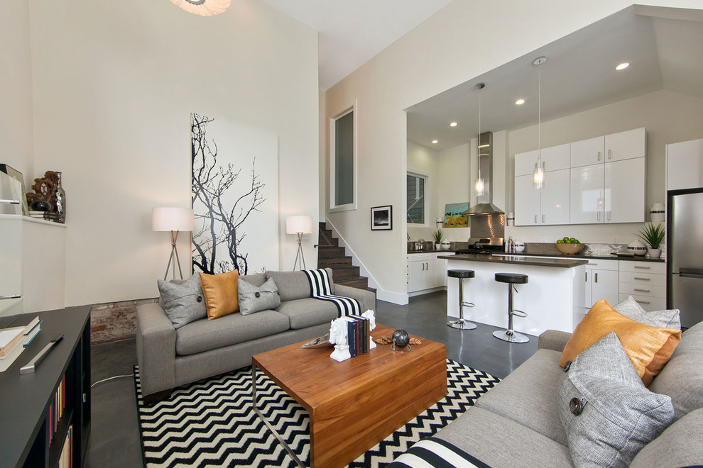 Стильный дизайн: парадная, открытая гостиная комната в современном стиле с белыми стенами и бетонным полом - последний тренд