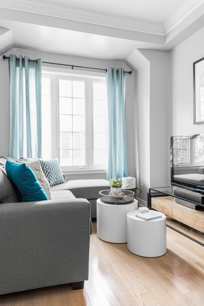 Пример оригинального дизайна: гостиная комната среднего размера в современном стиле с серыми стенами, отдельно стоящим телевизором, бежевым полом и синими шторами
