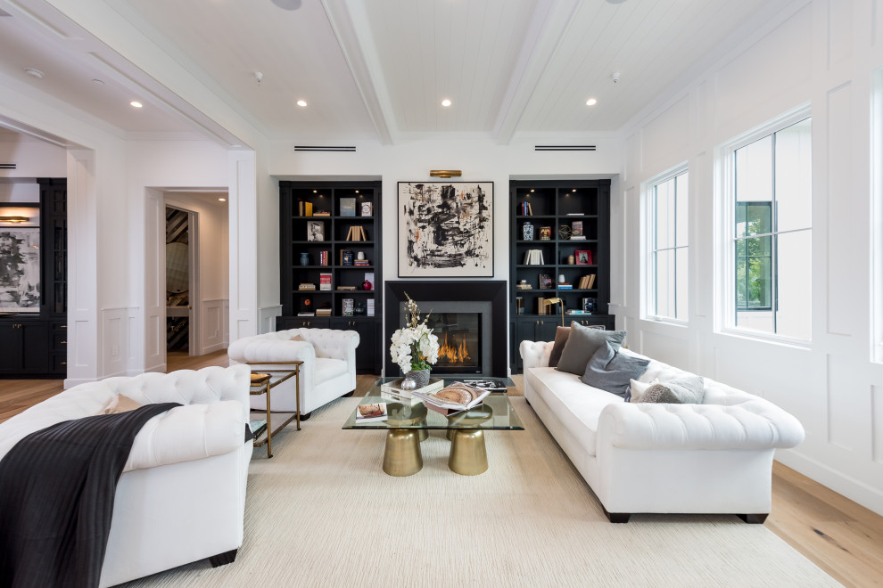 Abgetrenntes Klassisches Wohnzimmer mit weißer Wandfarbe, braunem Holzboden, Kamin, braunem Boden und Wandpaneelen in Los Angeles