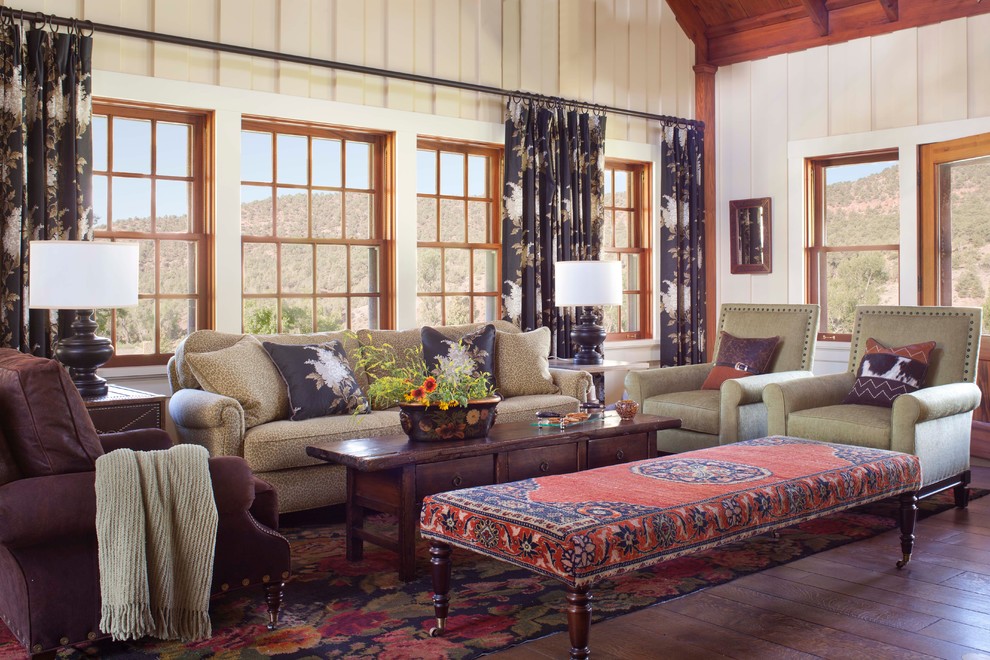 Modelo de salón rural con paredes beige, suelo de madera oscura y cortinas