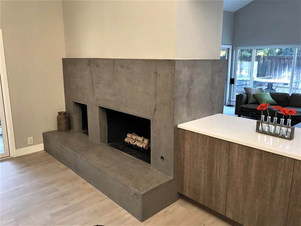 Inspiration for a medium sized contemporary open plan living room in Los Angeles with a two-sided fireplace, grey floors, a home bar, white walls, light hardwood flooring, a stone fireplace surround and a wall mounted tv.