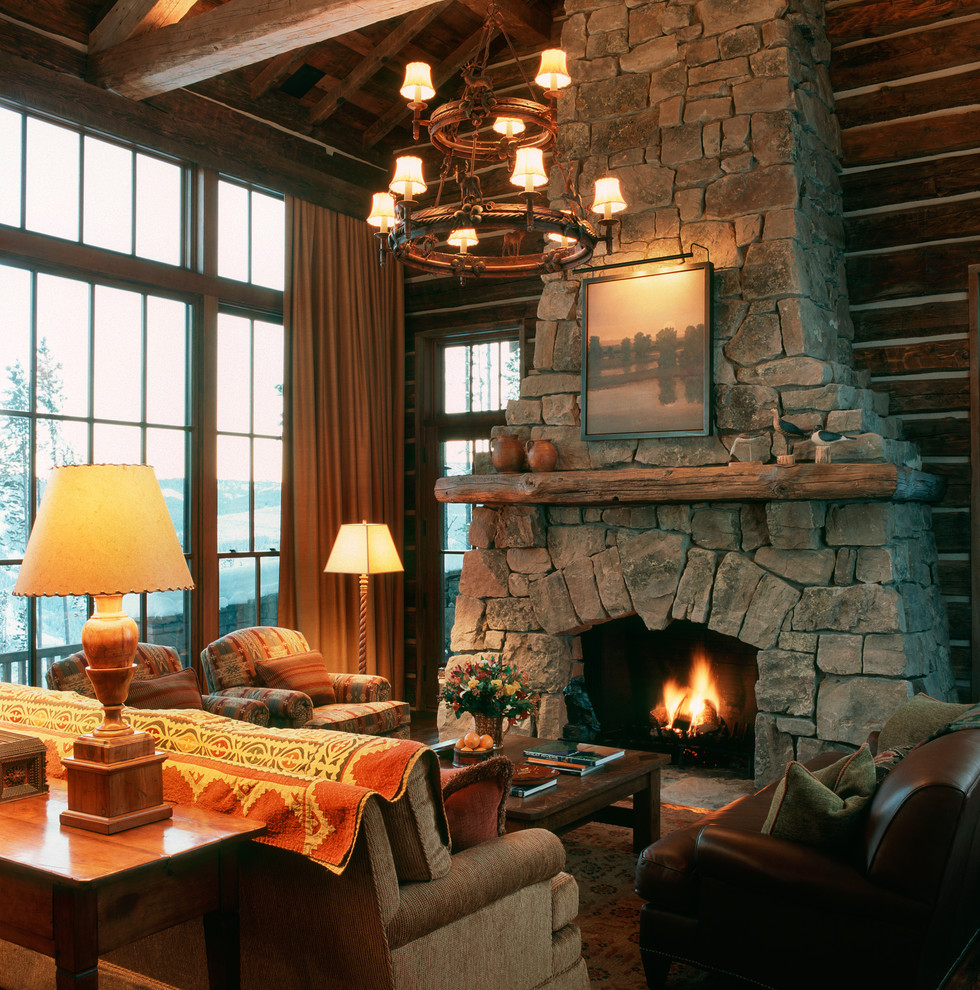 На фото: гостиная комната:: освещение в стиле рустика с стандартным камином и фасадом камина из камня с