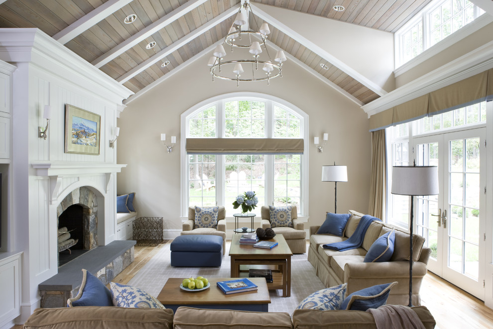 Example of a large classic enclosed vaulted ceiling living room design in DC Metro with beige walls, a standard fireplace and a stone fireplace